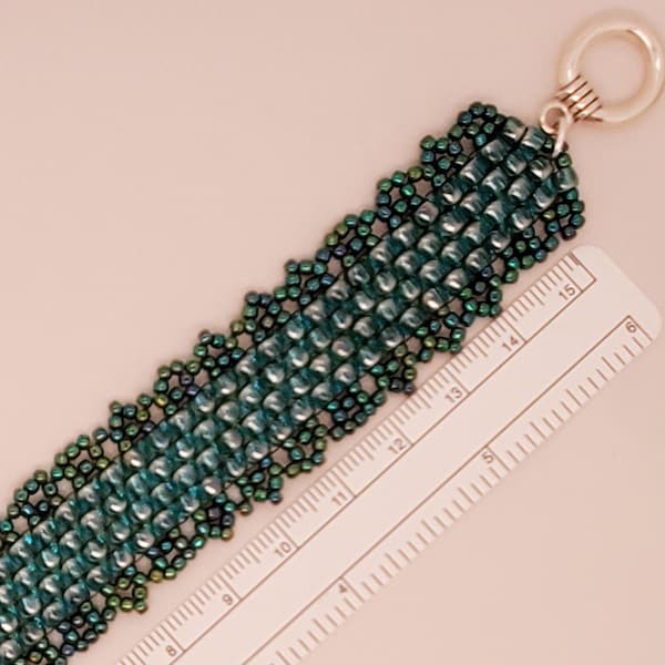 Iridescent Green Bracelet, peyote stitch band of translucent 6/0 seed beads, edge netted opaque iridescent green seed beads, toggle clasp