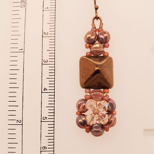 Betsy's Cupola Earrings have a large metallic bronze pyramid, Swarovski crystals and purple-bronze melon beads, thread guards, ear wires