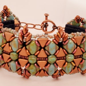 May include: A copper and turquoise beaded bracelet with a toggle clasp. The bracelet is made with small, faceted beads in a geometric pattern.
