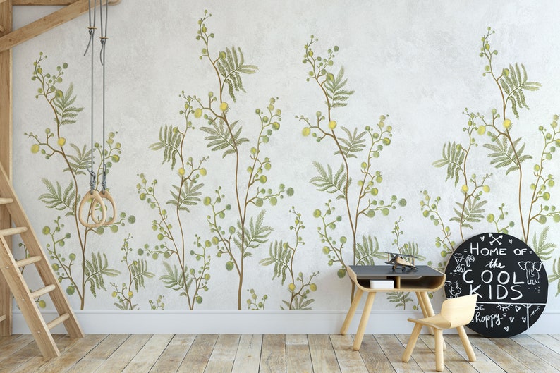 Pu&ograve; includere: Un muro bianco con una carta da parati floreale verde e gialla. Una scala di legno si trova sul lato sinistro dell'immagine. Una scrivania e una sedia in legno si trovano sul lato destro dell'immagine. Una lavagna nera con il testo "Home of the Cool Kids" &egrave; appesa al muro.