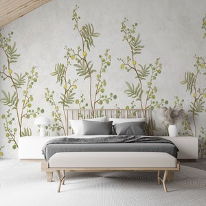 Pu&ograve; includere: Una camera da letto con un letto e una carta da parati floreale. La carta da parati presenta un motivo di foglie verdi e fiori gialli. Il letto ha una testiera grigia e un copriletto bianco.