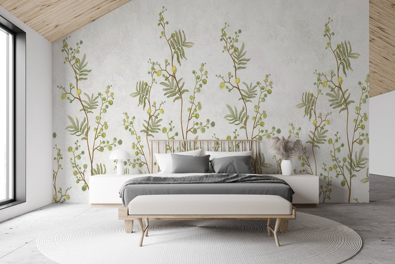 Pu&ograve; includere: Una camera da letto con un letto e una carta da parati floreale. La carta da parati presenta un motivo di foglie verdi e fiori gialli. Il letto ha una testiera grigia e un copriletto bianco.