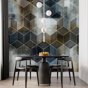 May include: A black dining table with four black chairs and a modern light fixture with five white globe lights hanging above it. The table is set with a bowl of fruit. The wall behind the table is covered in a geometric wallpaper with a blue, gray, and gold color scheme.