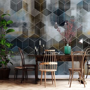 May include: A dining room with a wooden table and chairs set against a wall with a geometric patterned wallpaper. The wallpaper features a repeating pattern of blue, gray, and gold cubes. A potted plant is in the corner of the room.
