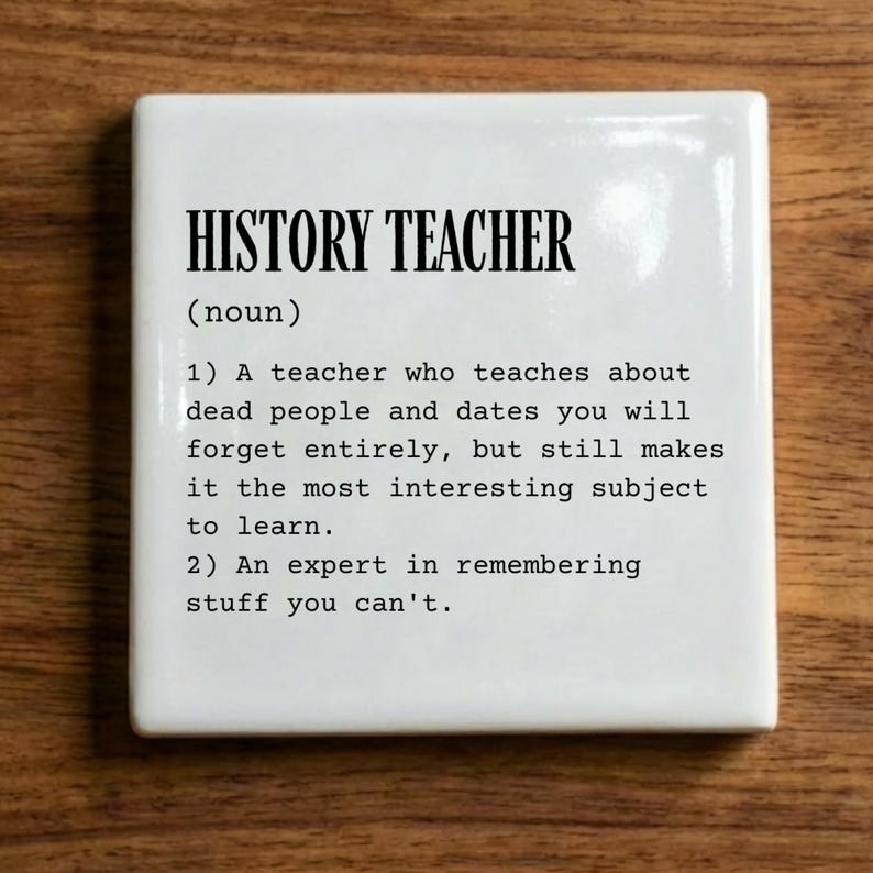 May include: A square white ceramic tile featuring black printed text that defines a history teacher as someone who teaches about dead people and dates you will forget, but makes the subject interesting, and an expert in remembering stuff you can't.