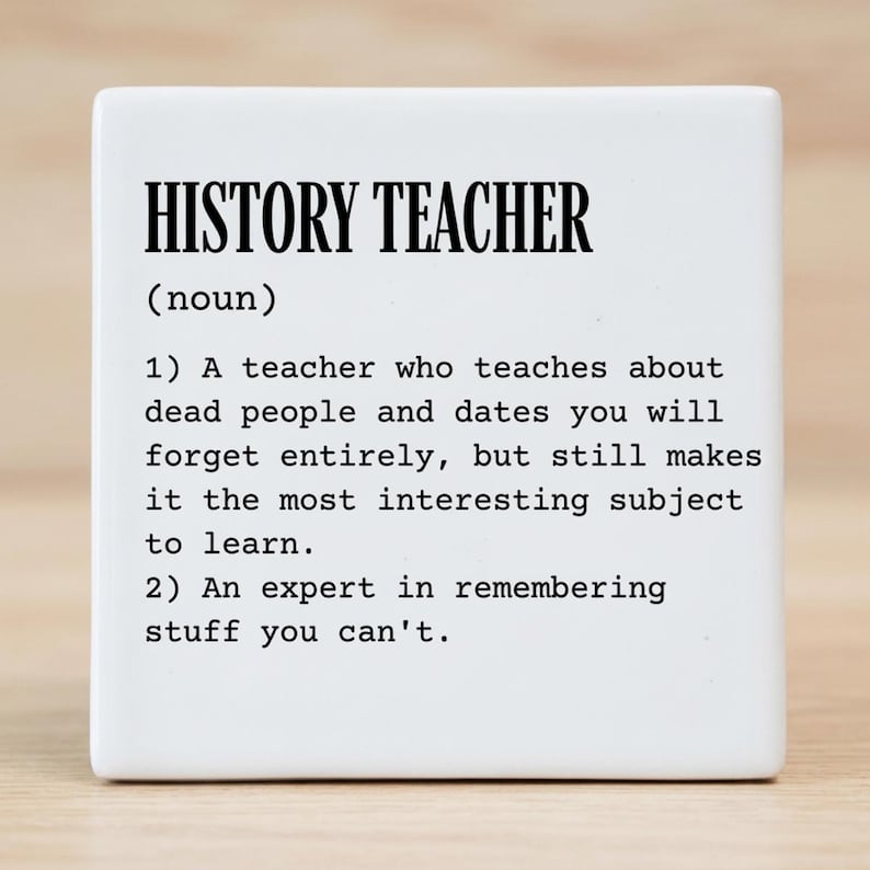 May include: A square white ceramic tile featuring black printed text that defines a history teacher as a noun. The text includes two numbered definitions describing a teacher who covers dead people and dates, and an expert in remembering facts.