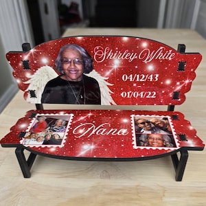 Könnte beinhalten: Ein dekoratives, bankförmiges Denkmal mit rotem Glitzerhintergrund. Der obere Teil zeigt ein Foto einer Frau, den Namen "Shirley White" und Daten. Der untere Teil trägt den Namen "Nana" und zwei Fotocollagen. Die Bank wird von schwarzen Beinen getragen.