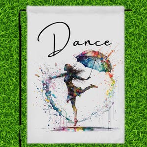 May include: A white garden flag with the word "Dance" in black script. A watercolor illustration of a woman dancing with a colorful umbrella in a circle of colorful water droplets.
