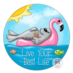 May include: A gray seal wearing sunglasses relaxes on a pink flamingo pool float in a blue ocean with a yellow sun and white clouds. The seal is holding a glass of orange juice with a straw. The text "Live Your Best Life" is written in white on the blue water. The image is a digital illustration.