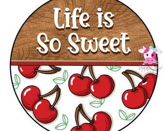May include: A circular sign featuring a wood grain top section with the white text Life is So Sweet. The bottom section has a white background with a pattern of red cherries with brown stems and green leaves, plus a small cow logo on the right.