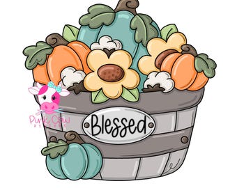 May include: A gray wooden basket filled with orange and teal pumpkins, light yellow flowers, and white cotton bolls. An oval plaque on the front of the basket features the word Blessed in black script. A small pink cow logo is visible on the left.