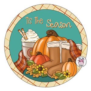 Puede incluir: Un fondo redondo de color turquesa con un borde a cuadros. El texto "Tis the Season" está escrito en blanco. La imagen presenta una calabaza, una taza de café con crema batida y dos pajitas, dos botas marrones y una bufanda a cuadros. También hay girasoles y hojas de otoño.