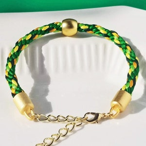 St Patrick's Day pot O' gold bracelet, satin thread woven in a green Spring color mix w/ a matte gold round bead & matching adjustable clasp