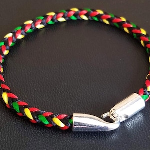 May include: A braided bracelet with black, red and yellow cords and a silver clasp.