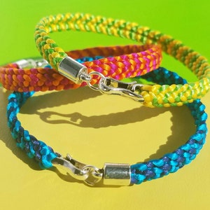 May include: Three braided bracelets in blue, yellow, and orange with silver clasps.