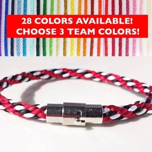 Op de afbeelding: Een rood, wit en zwart gevlochten armband met een zilveren sluiting. 28 KLEUREN BESCHIKBAAR! KIES 3 TEAMKLEUREN!