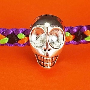 Halloween party bracelet, Halloween skull bracelet, hand-woven flat braid in Halloween color mix w/ a silver skull bead and adjustable clasp