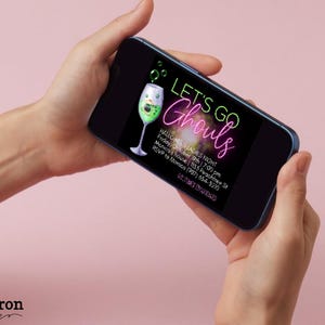 May include: A digital invitation for a Halloween party with the text "Let's Go Ghouls" in neon green and pink lettering. The invitation features a green cocktail with a spooky face and a black background.