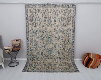 May include: A vintage rug with a floral pattern in shades of blue, green, and white on a cream background. The rug has a faded, distressed look and is perfect for adding a touch of bohemian style to any room.