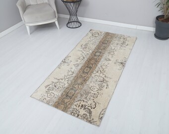 May include: A vintage style runner rug with a beige background and a brown floral pattern. The rug has a distressed look and is perfect for adding a touch of vintage charm to any room.