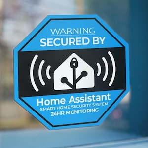 May include: A blue and black octagonal security sign with white text and graphics. The sign reads "WARNING SECURED BY Home Assistant SMART HOME SECURITY SYSTEM 24HR MONITORING". The graphic is a house with a lock and signal waves.