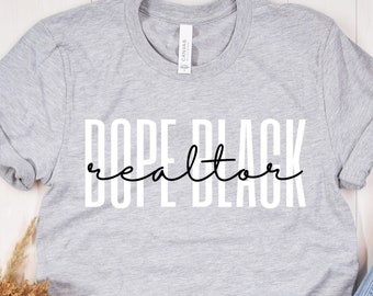 May include: A gray t-shirt with the text "Dope Black Realtor" printed in white and black.