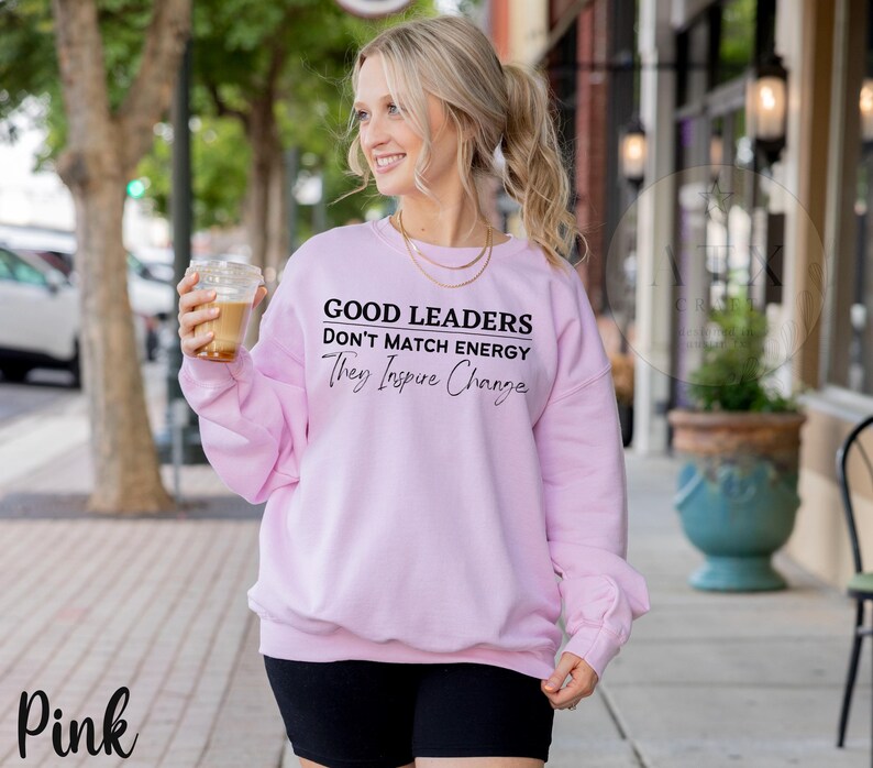 a woman walking down the street with a drink in her hand