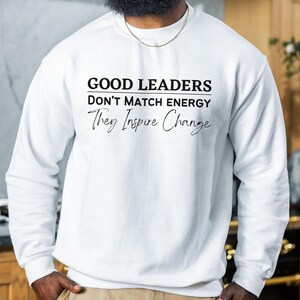 a man wearing a sweatshirt that says good leaders don't match energy