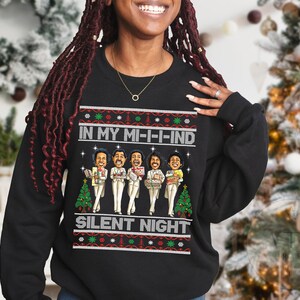 May include: Black Christmas sweater with a festive design featuring a group of cartoon singers and the text "In My Mi-i-ind Silent Night".