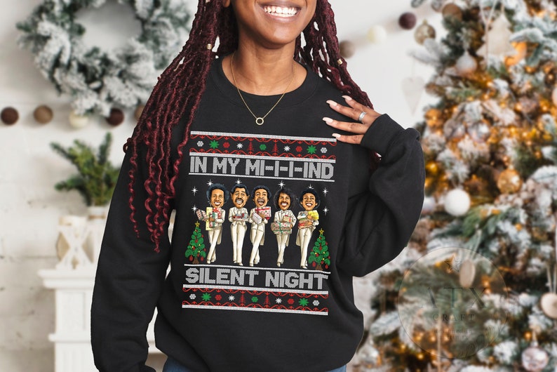 May include: Black Christmas sweater with a festive design featuring a group of cartoon singers and the text "In My Mi-i-ind Silent Night".