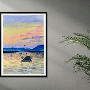 May include: A framed watercolour painting depicting a sailboat on tranquil water at sunset. The sky transitions from yellow to pink and blue, with the boat's reflection visible. The artwork is in a black frame.