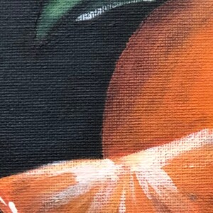Puede incluir: Primer plano de una rodaja de naranja y un segmento de naranja, pintados sobre un fondo negro. La rodaja de naranja es de un naranja vibrante con detalles blancos, y se ve una hoja verde.
