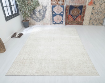 May include: A white shag rug with a subtle distressed pattern. The rug is laid out on a light wood floor.