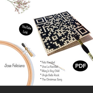 May include: A cross-stitch pattern in black and white, resembling a QR code, with a list of Christmas song titles. The image includes a wooden embroidery hoop, black embroidery floss, and the text "Jose Feliciano" and "PDF". A YouTube link is also present.