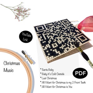 May include: A cross-stitch pattern with a black and white geometric design. The image includes a wooden embroidery hoop, black thread, and a list of Christmas songs: "Santa Baby", "Baby it's Cold Outside", "Last Christmas", "All I Want for Christmas is my 2 Front Teeth", and "All I Want for Christmas is You".