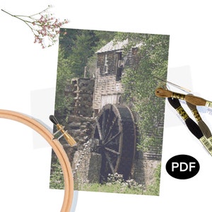 Puede incluir: Un patrón de punto de cruz que presenta una imagen detallada de un molino de agua con una gran rueda de madera, un edificio de piedra y vegetación exuberante.