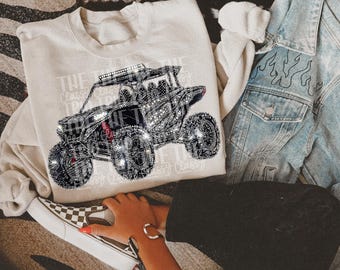 May include: A white sweatshirt with a rhinestone design of an off-road vehicle. The vehicle is surrounded by the text "The  Classic  Classics".