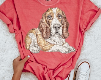 May include: A coral pink t-shirt with a sparkly brown and white basset hound graphic.