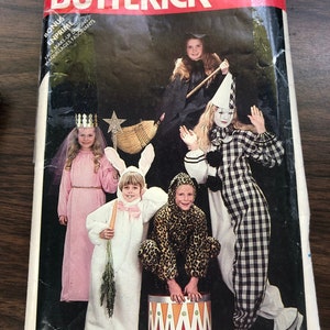 May include: A vintage sewing pattern for children's costumes. The pattern includes five costumes: a witch, a clown, a bunny, a lion, and a princess. The pattern is from Butterick and the pattern number is 337.