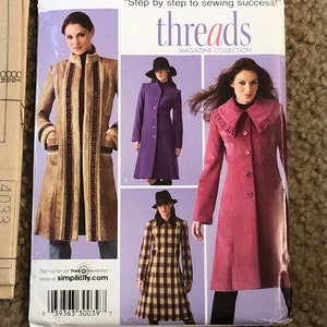 May include: A sewing pattern for a coat with three different styles. The pattern is from Simplicity Threads Magazine Collection and is size H5, 6, 8, 10, 12, 14. The pattern is for a coat with a collar, buttons, and pockets. The pattern is available in sizes 32-40 EUR and 34-42 FR.