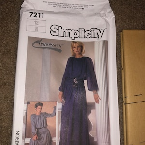 May include: Simplicity sewing pattern number 7211 for a long dress with a high neckline and long sleeves. The pattern includes two views, one with a gathered skirt and one with a straight skirt. The pattern is for sizes 12-40.