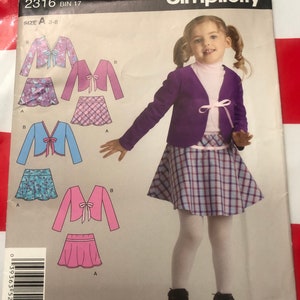 May include: A sewing pattern for a girl's outfit. The pattern includes a cardigan with a bow tie and a plaid skirt. The pattern is for sizes 3-8. The pattern number is 2316.