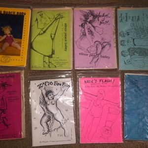 May include: Eight colorful paperbacks with illustrations and text. The titles include "The Beach Babe", "Zaftig Fire Fairy", "Nude's Flash", "Amethyst and the Eel", "Dee Dee Howard and Olive Slan", and "Mountain Pell".