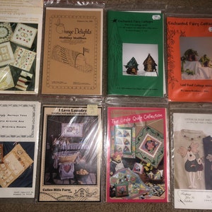 May include: A collection of eight craft patterns featuring various themes, including holiday mailboxes, fairy cottages, laundry, and quilts. The patterns are printed on white paper with colorful illustrations and text.
