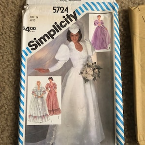May include: A Simplicity sewing pattern for a wedding dress. The pattern is for size 14 and includes three different views. The pattern is $4.00. The pattern number is 5724.
