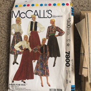 May include: A vintage McCall's sewing pattern for a dress, featuring four different styles. The pattern number is 7800 and the size is 10, bust 32 1/4 inches. The pattern is titled "Made-for-You" and includes bust cup size adjustment darts and back and shoulder adjustment cutting lines.