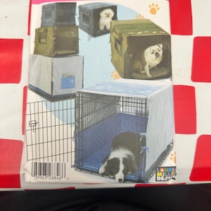 May include: A Simplicity 4713 sewing pattern envelope for pet crate covers. The packaging features illustrations of various dogs inside wire crates with fabric covers in olive green, light blue, and dark gray, including paw print accents.