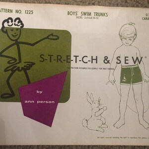 May include: A vintage sewing pattern for boys' swim trunks, featuring a cartoon illustration of a stick figure wearing a tutu and the text "S-T-R-E-T-C-H & SEW". The pattern is designed exclusively for knit fabrics and is by Ann Person.