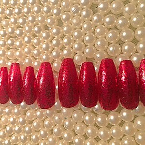 May include: Set of ten red glitter coffin-shaped false nails.