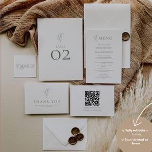 Pode incluir: Um conjunto de papelaria de casamento branca com ilustrações botânicas minimalistas. Inclui um número de mesa, um menu, um cartão de agradecimento e um cartão com um código QR. O texto inclui "MARIE", "TABLE 02" e "THANK YOU".